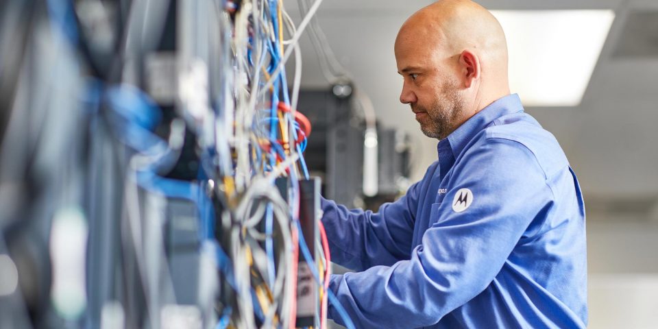 Male employee of R.A. Moore adjusting a piece of automation equipment