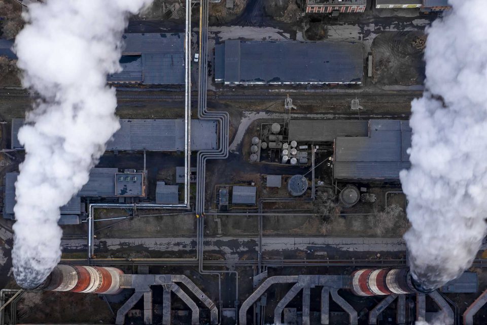 Aerial view of a industrial plant with smoke billowing out from towers